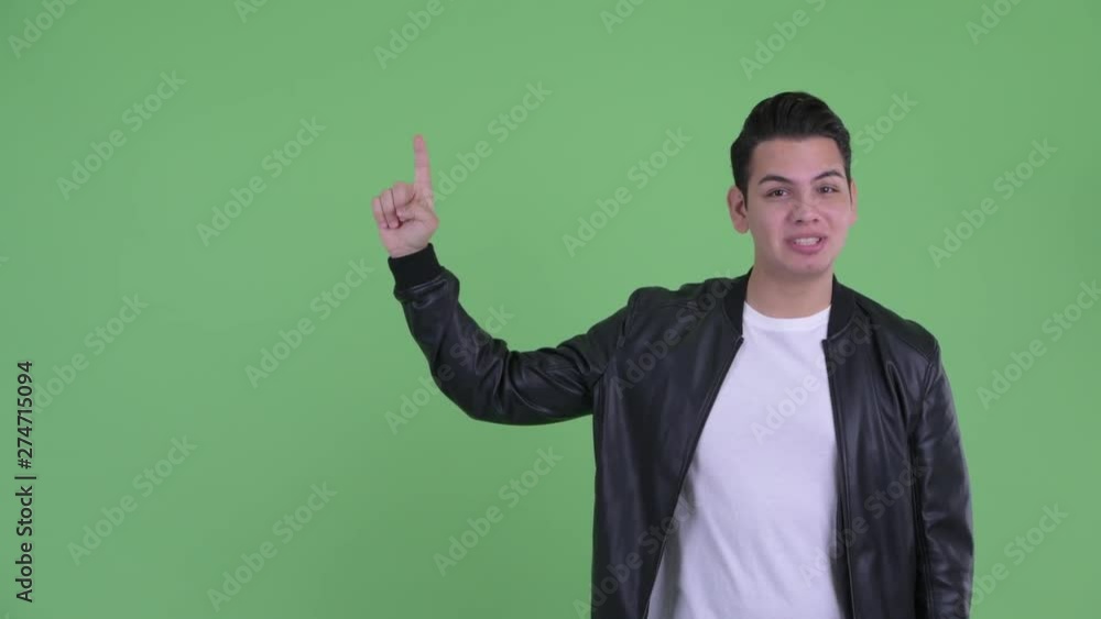 Happy young handsome multi ethnic man talking while pointing up Happy young handsome multi ethnic man talking while pointing up