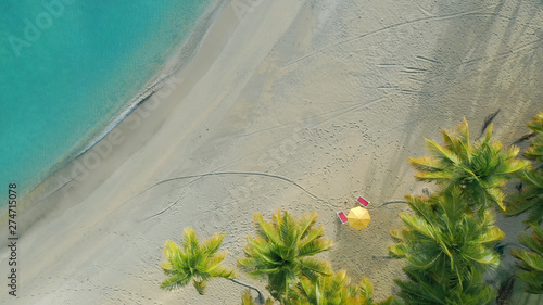 Maldives beach with white sand and turquoise sea, top view. Beautiful coconut palms on the coast of the Indian Ocean. Beautiful beach landscape. Journey to a tropical paradise.