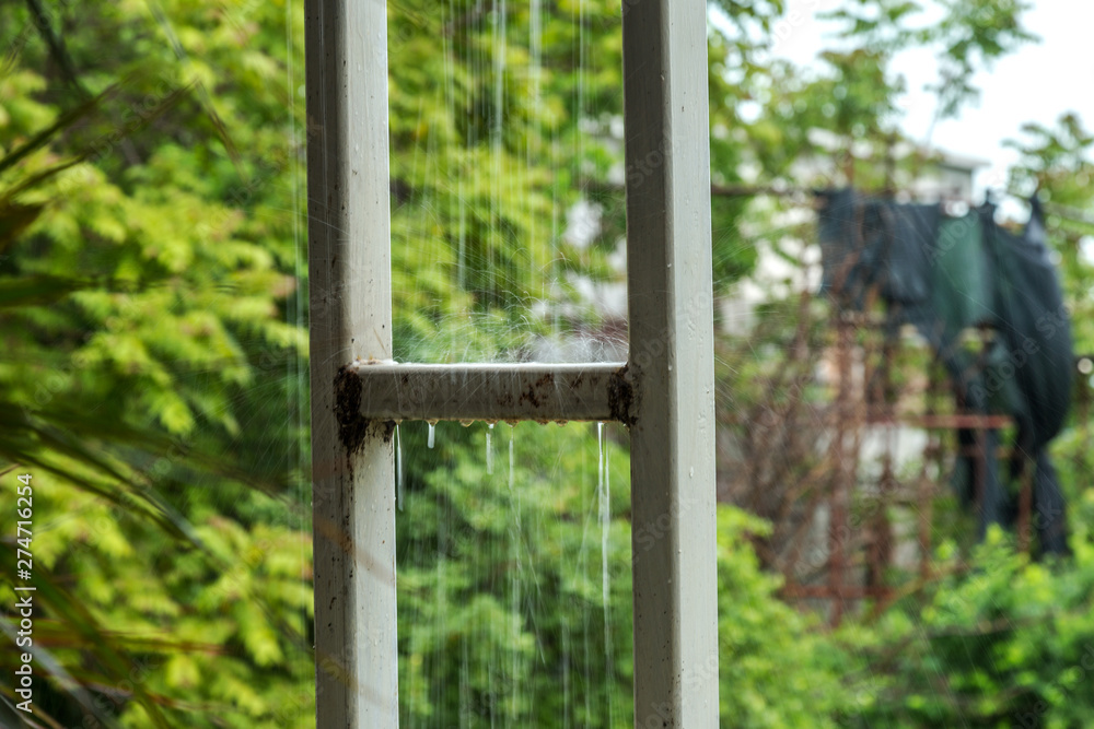 Abstract background of raindrops on the balcony rack. Summer rain. Rain spray in backlight. Abstract warm summer background Abstract background of raindrops on the balcony rack. Summer rain. Rain spray in backlight. Abstract warm summer background