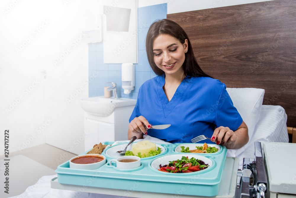 Tray with breakfast for the young female patient. The young woman eating in the hospital. Tray with breakfast for the young female patient. The young woman eating in the hospital.