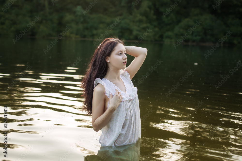 Fototapeta premium Woman in nightie is bathing in the lake.