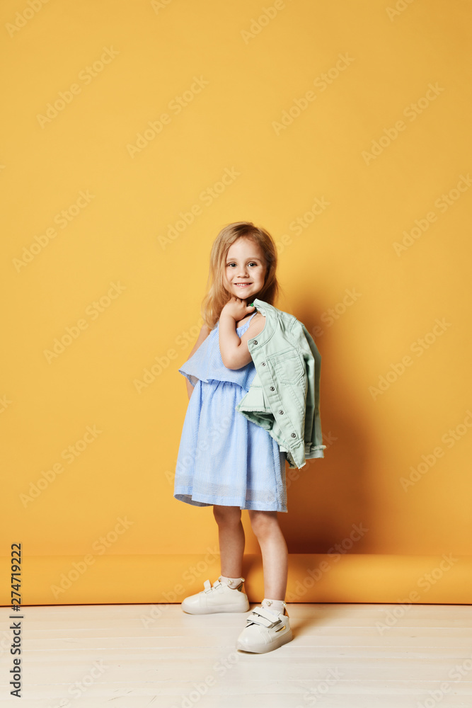 Full length portrait of a cute little child girl in a stylish dress and denim. Full length portrait of a cute little child girl in a stylish dress and denim.