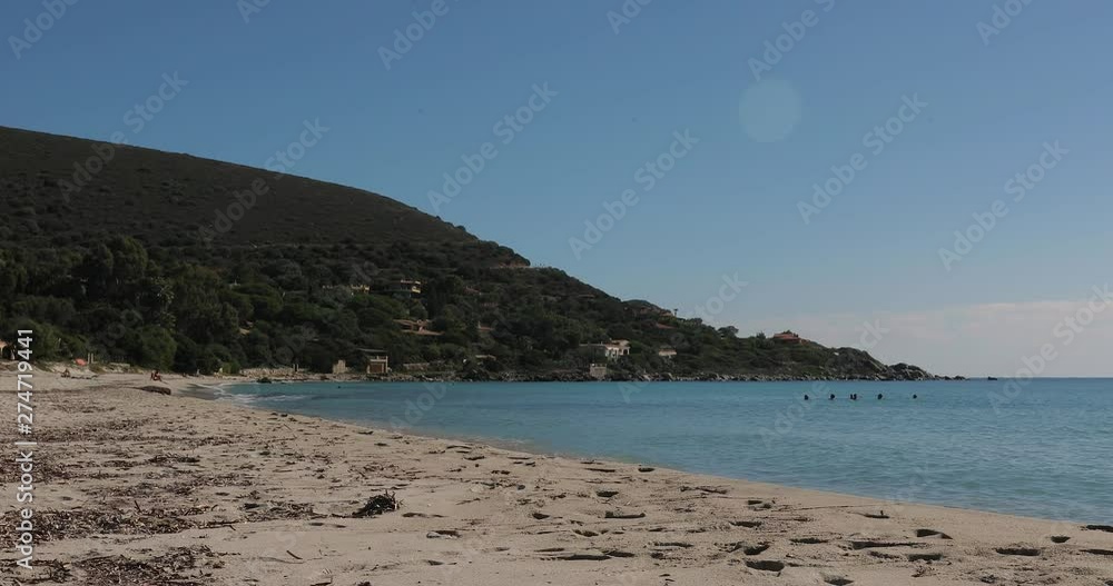 Calming beach seascape across Cagliari, Sardinia golden sandy beach & lush green vegetation mountain slope on the horizon. Calming beach seascape across Cagliari, Sardinia golden sandy beach & lush green vegetation mountain slope on the horizon.