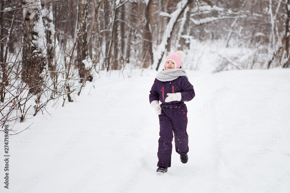 Young girl in winter snowy forest.