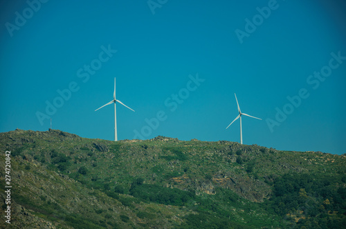 Wind turbines for electric power generation over hill