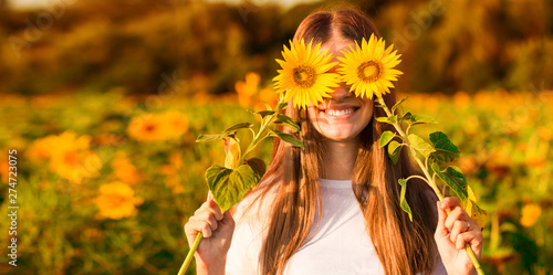 Summer portrait. Happy joyful girl with sunflower enjoying nature and laughing on sunflower field