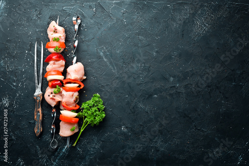 Raw chicken shish kebab with vegetables and spices. Top view. Free space for your text. Rustic style.