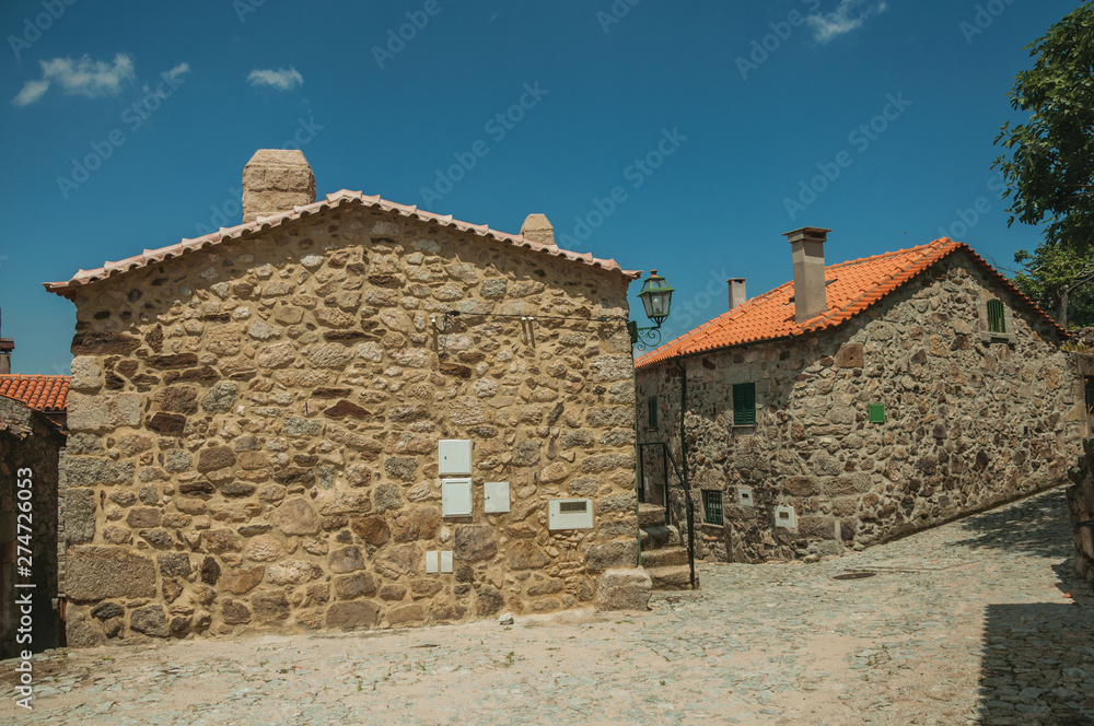 Cobblestone alley on slope and old stone houses