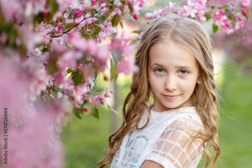 candid portrait of a girl in a blooming apple orchard