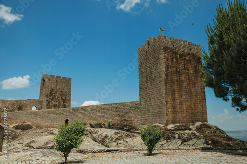 Stone wall and square tower from castle over rocky hill