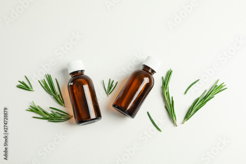 Fototapeta Naklejka Na Ścianę i Meble -  Flat lay composition with rosemary oil and leaves on white background, space for text