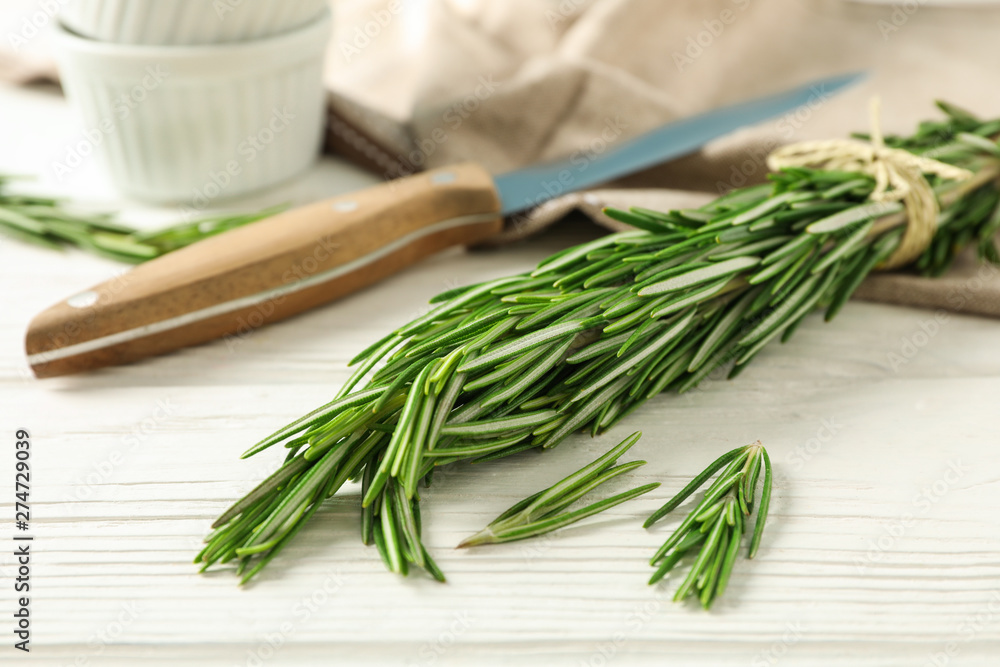 Composition with rosemary, knife, towel and sauceboats on white background Composition with rosemary, knife, towel and sauceboats on white background