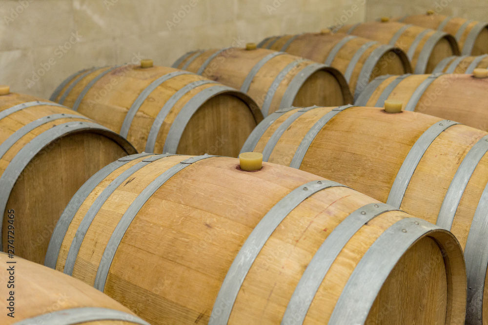 Wine barrels stacked in the cellar of the winery. Wine barrels in wine-vaults.