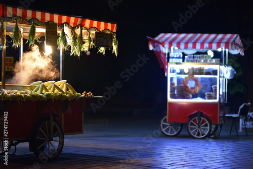Street food carts in night. Text on signboards in translation from Turkish language on English is Roasted chestnuts and corn. photo