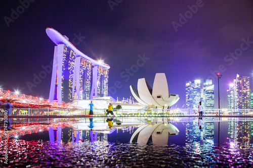SINGAPORE, SINGAPORE - MARCH 2019: Skyline of Singapore Marina Bay at night with Marina Bay sands and Art Science museum reflecting in a pond after rain. Vibrant night scene