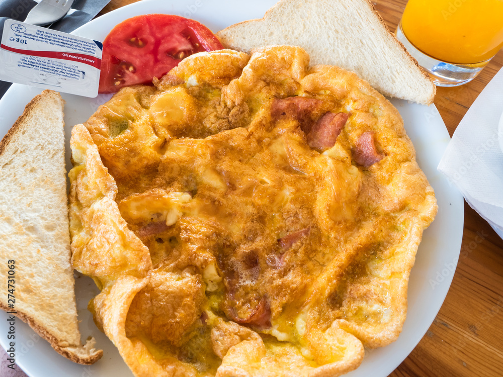 rustic breakfast with omelette with bacon and cheese, slices of toast, butter and tomato, orange juice to drink rustic breakfast with omelette with bacon and cheese, slices of toast, butter and tomato, orange juice to drink