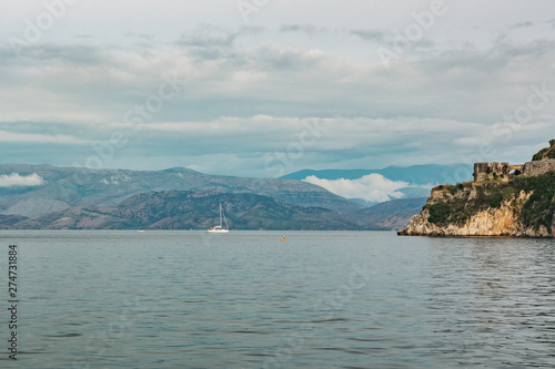 Sailboat in the sea in the sunlight over beautiful big mountains background, lsummer adventure, active vacation in Mediterranean sea.