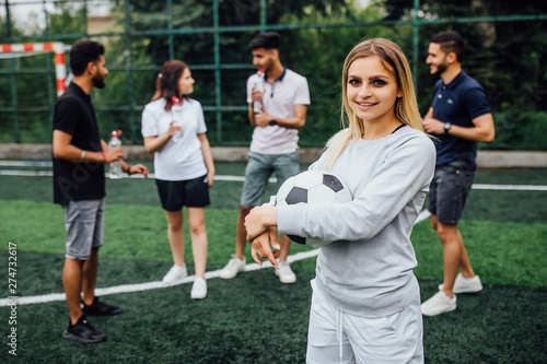 Young, blonde  woman smiling and happy, holding a soccer ball, competitive attitude, excited to play a game.. © Тарас Нагирняк