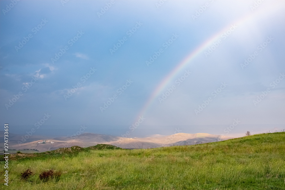 Wonderful landscape view over Basilicata countryside on a stormy day with a rainbow. Monteserico castle, Italy