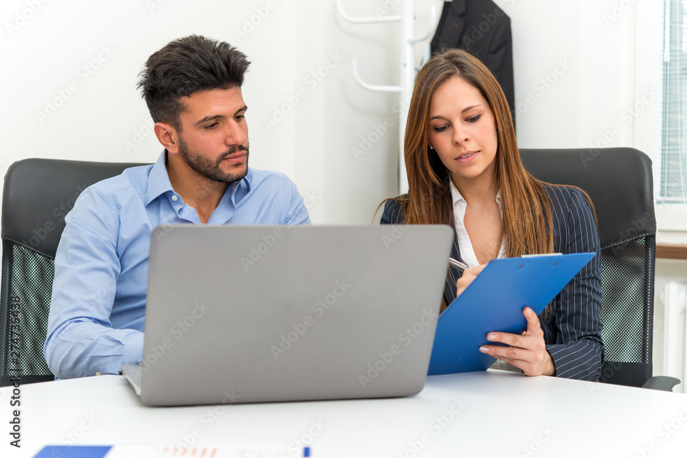 Team using a laptop computer in her office Team using a laptop computer in her office