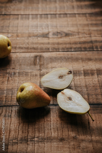 Cut yellow pears on wooden background