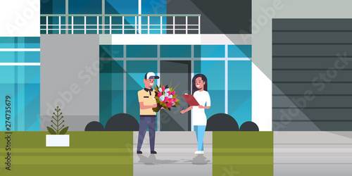 courier man giving bouquet of flowers to woman recipient express delivery service concept girl receiving parcel from deliveryman modern building exterior horizontal full length