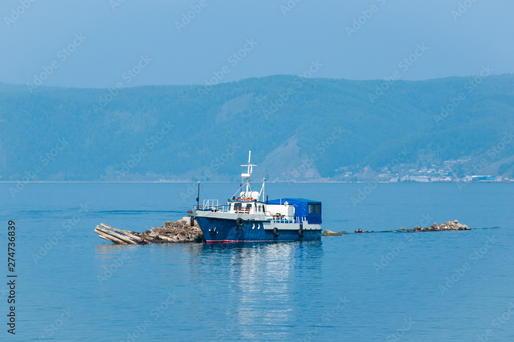 The blue ship anchored on lake Baikal on a Sunny day.