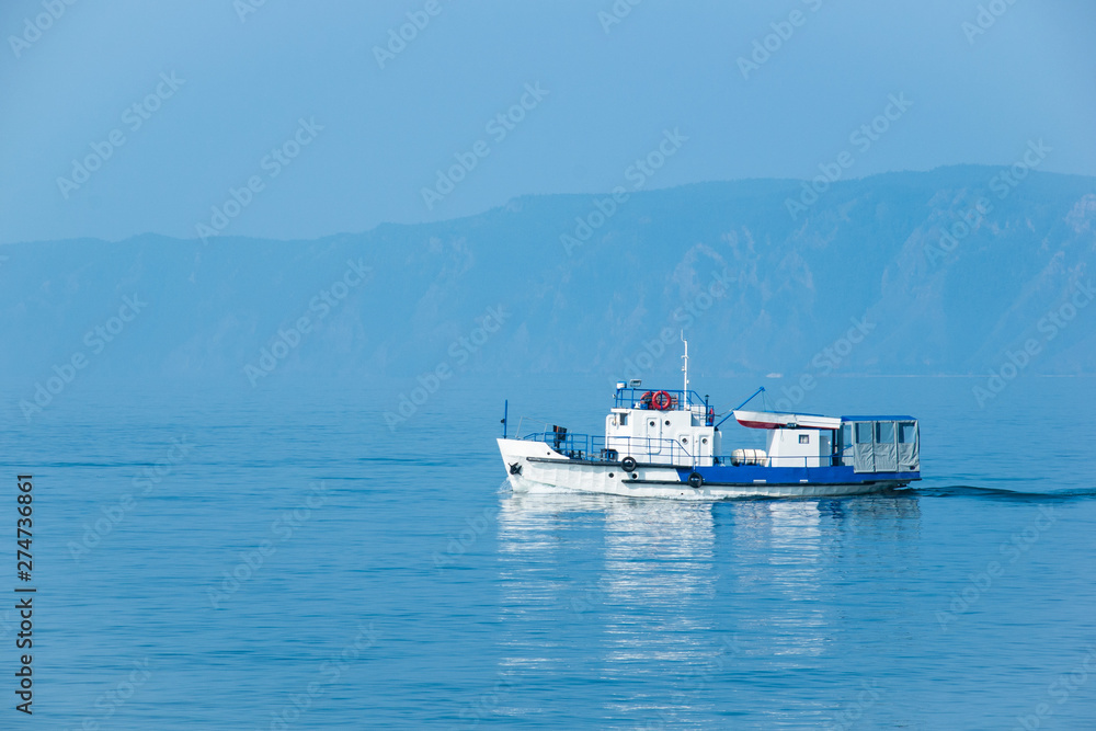 The white ship sails on lake Baikal on a Sunny day.