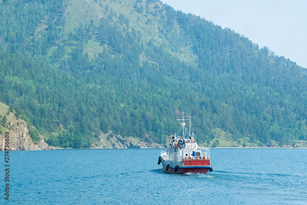 The waterbus with turists sails on lake Baikal on a Sunny day.