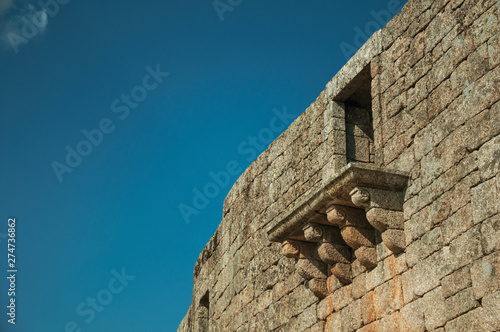 Balcony in gothic style on a wall made of stone bricks