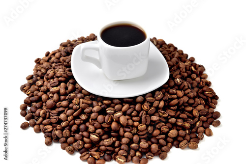 white cup of coffee on a white saucer stands on a hill of coffee beans on a white background angle view from above
