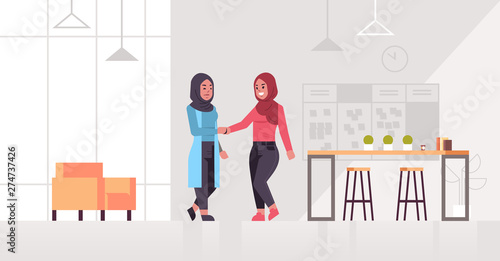 arabic businesswomen handshaking arab business partners couple hand shake during meeting agreement partnership concept modern co-working center office interior full length horizontal