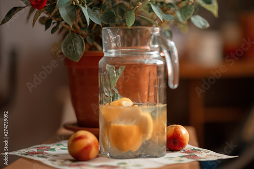 pitcher of water with lemon and mint on a stool