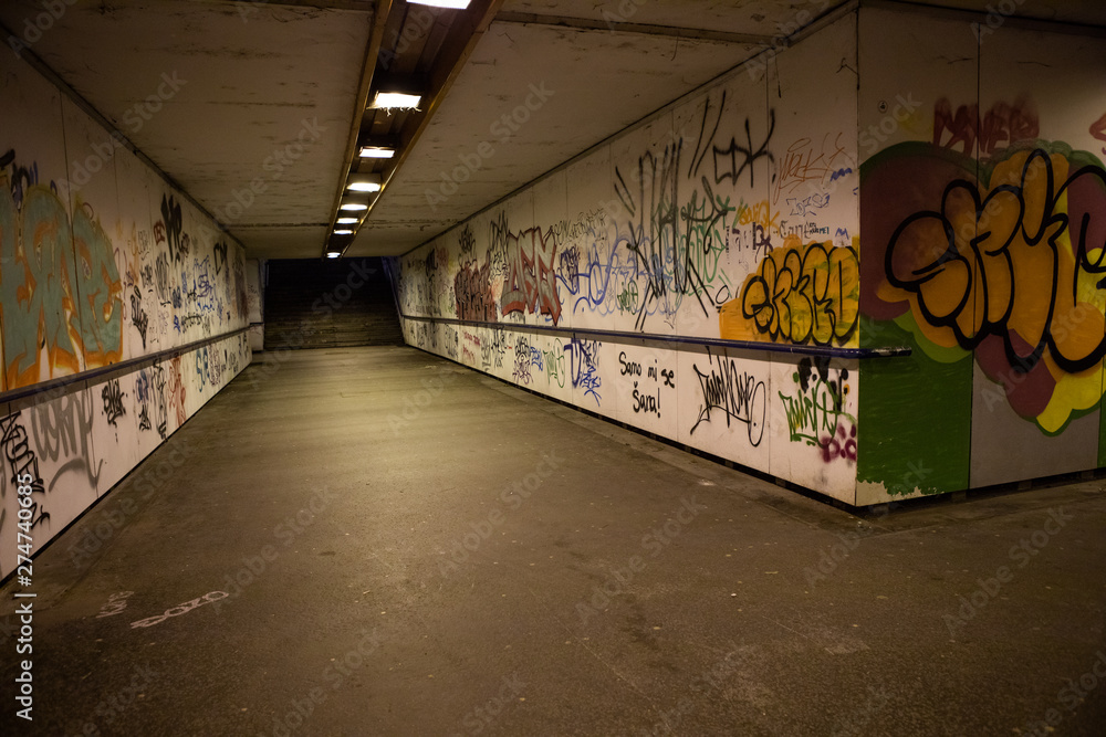 Croatia, Zagreb, June 21, the dark passage of a deserted, eerie creepy concrete indoor pathway grafted with graffiti at night