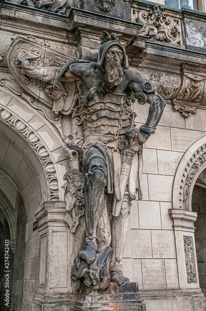 Very old statute of scary gatekeeper, medieval warrior with weapon in historical downtown of Dresden, Germany