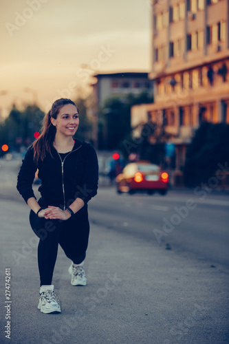 Girl stretching her legs on river bridge, preparing for evening workout