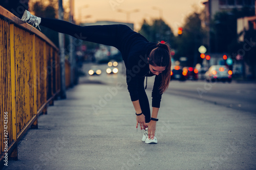 Girl doing stretching exercise on the bridge, at night