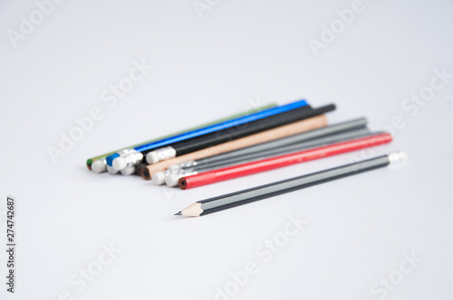 pencils of different colors scattered on a white table. On a white background.