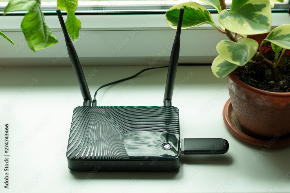 insert a mobile usb into Internet router on the window sill by the window Stock Photo | Adobe Stock
