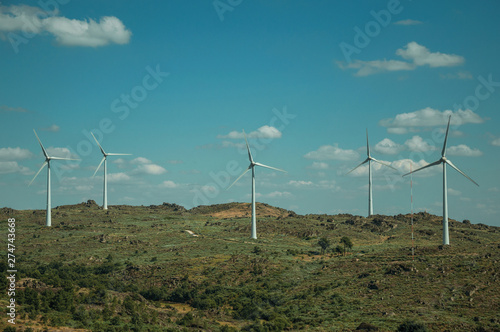 Several wind turbines over hilly landscape