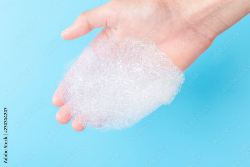Foam with large bubbles in his hand on a blue background Foam with large bubbles in his hand on a blue background