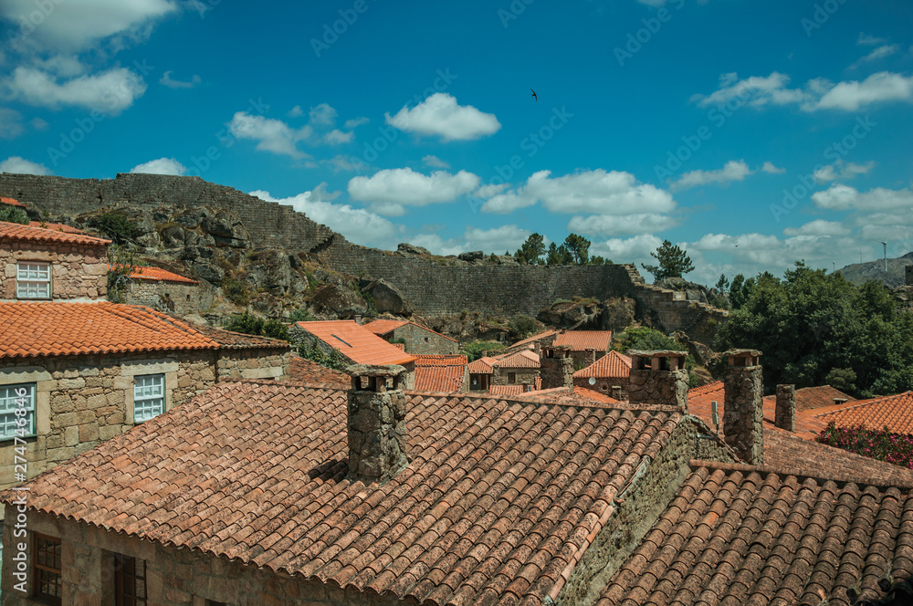 Rooftops of old houses with chimneys and large wall