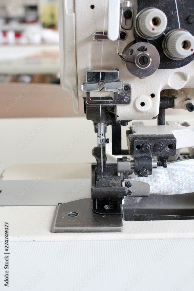 Close-up of industrial sewing machine needle. Textile factory - sewing machines.