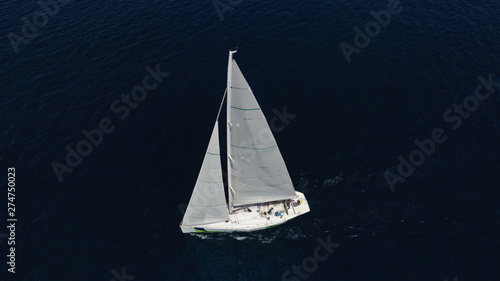 Aerial drone photo of sail boat cruising the deep blue Aegean sea, Greece © aerial-drone