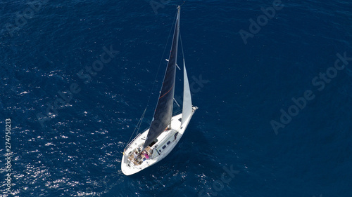 Aerial photo of sail boat cruising open ocean deep blue sea