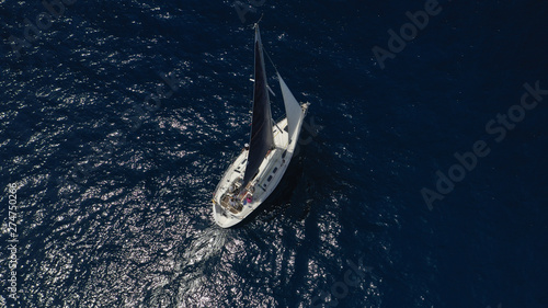 Aerial photo of sail boat cruising open ocean deep blue sea