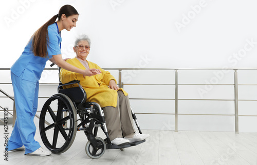 Nurse assisting senior woman in wheelchair at hospital