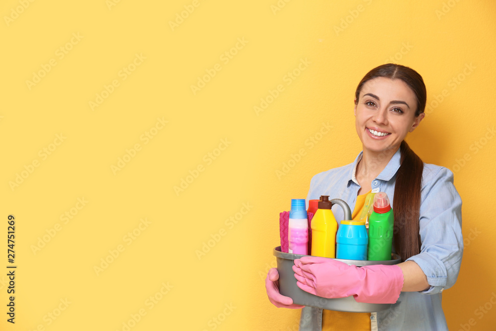 Woman with basin of detergents on color background. Space for text Woman with basin of detergents on color background. Space for text