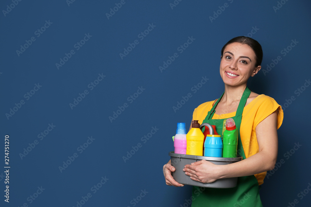 Woman with basin of detergents on color background. Space for text Woman with basin of detergents on color background. Space for text