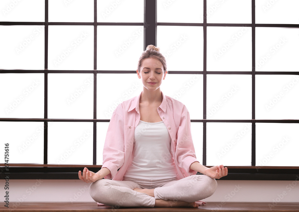 Young woman meditating at home. Zen concept